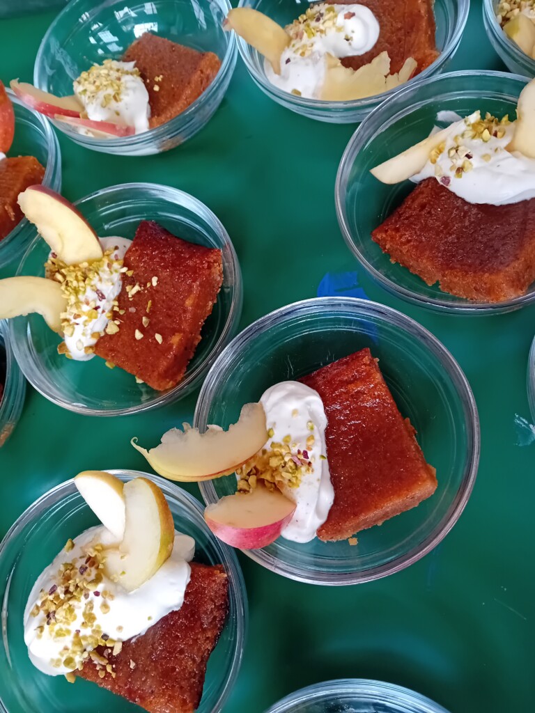 Petits desserts individuels : gateau de polenta à la pêche, yaourt, pistaches concassées, rondelles de pomme crue