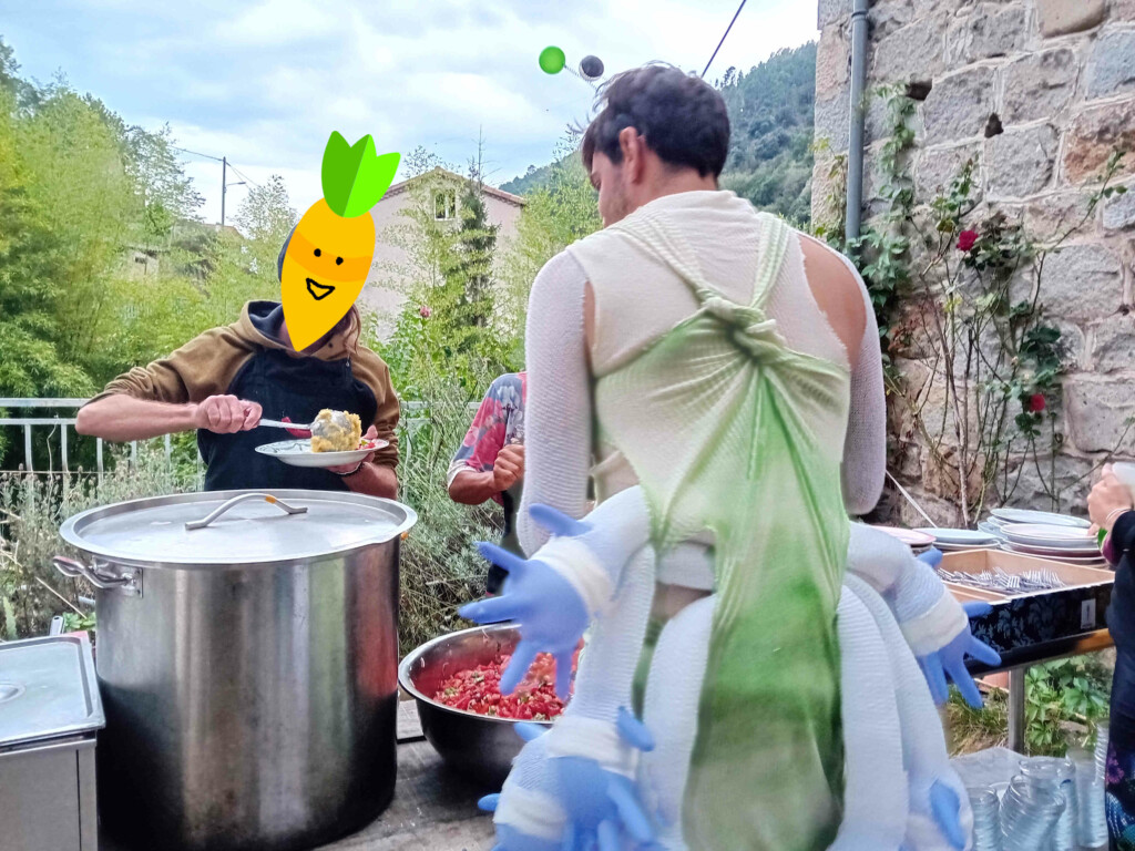 deux membres de la cantine chaubouillante servent son repas à une personne de dos, costumée.